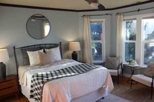 Bedroom with crown molding and wood finished floors