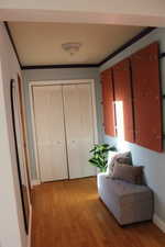 Living area with crown molding, baseboards, and wood finished floors