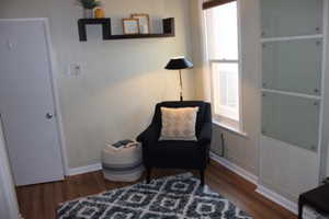 Living area featuring baseboards, wood finished floors, and a wealth of natural light