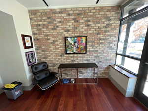Entryway featuring wood finished floors and brick accent wall