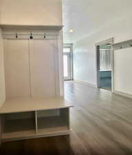 Mudroom with wood finished floors, a textured ceiling, and baseboards