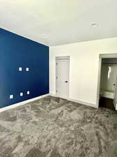 Unfurnished bedroom with visible vents, baseboards, and carpet flooring