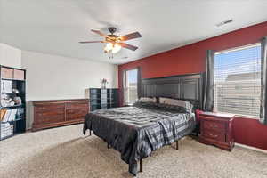 Bedroom with baseboards, visible vents, ceiling fan, and carpet