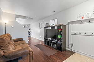 Living area featuring visible vents, baseboards, and wood finished floors