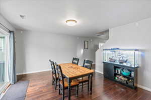 Dining area with visible vents, baseboards, and wood finished floors