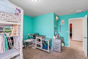 Carpeted bedroom featuring baseboards and visible vents