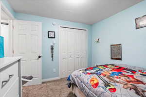 Bedroom featuring carpet, a closet, and baseboards