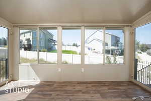 Unfurnished sunroom with plenty of natural light and wood finished floors