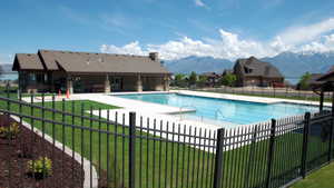 Pool featuring a yard, a mountain view, fence, and a patio area