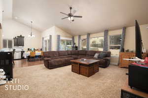 Living room featuring lofted ceiling, light colored carpet, and ceiling fan