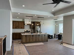 Kitchen with recessed lighting, wood finished floors, an island with sink, appliances with stainless steel finishes, and ceiling fan