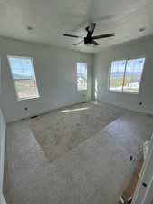 Empty room featuring baseboards, visible vents, a wealth of natural light, and carpet floors