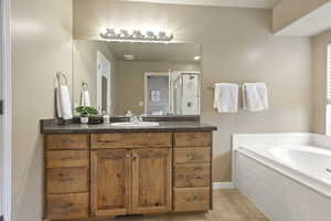 Bathroom with tile patterned flooring, vanity, and shower with separate bathtub