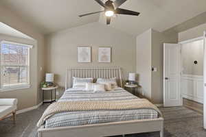 Bedroom with lofted ceiling, ceiling fan, and carpet flooring