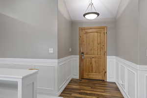 Doorway with dark hardwood / wood-style floors