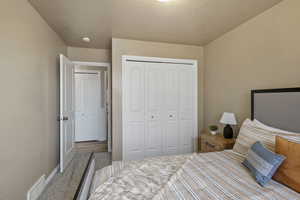 Carpeted bedroom featuring a closet and a textured ceiling