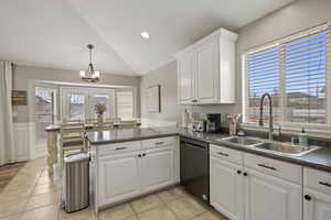 Kitchen with dishwasher, sink, white cabinets, and kitchen peninsula