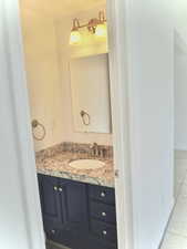 Bathroom with tile patterned floors and vanity