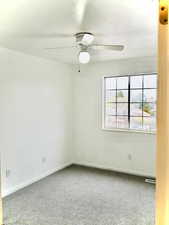 Spare room featuring visible vents, ceiling fan, carpet flooring, and baseboards
