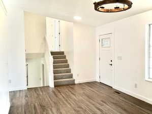 Foyer featuring wood finished floors, plenty of natural light, and stairs