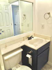 Half bathroom with tile patterned floors, vanity, and toilet