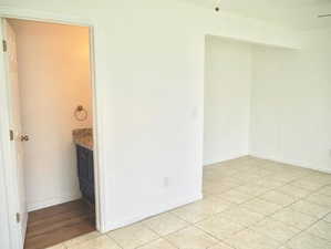 Unfurnished room featuring light tile patterned flooring and baseboards