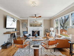 Living room with large picture window, hardwood floors and new gas fireplace and surround.