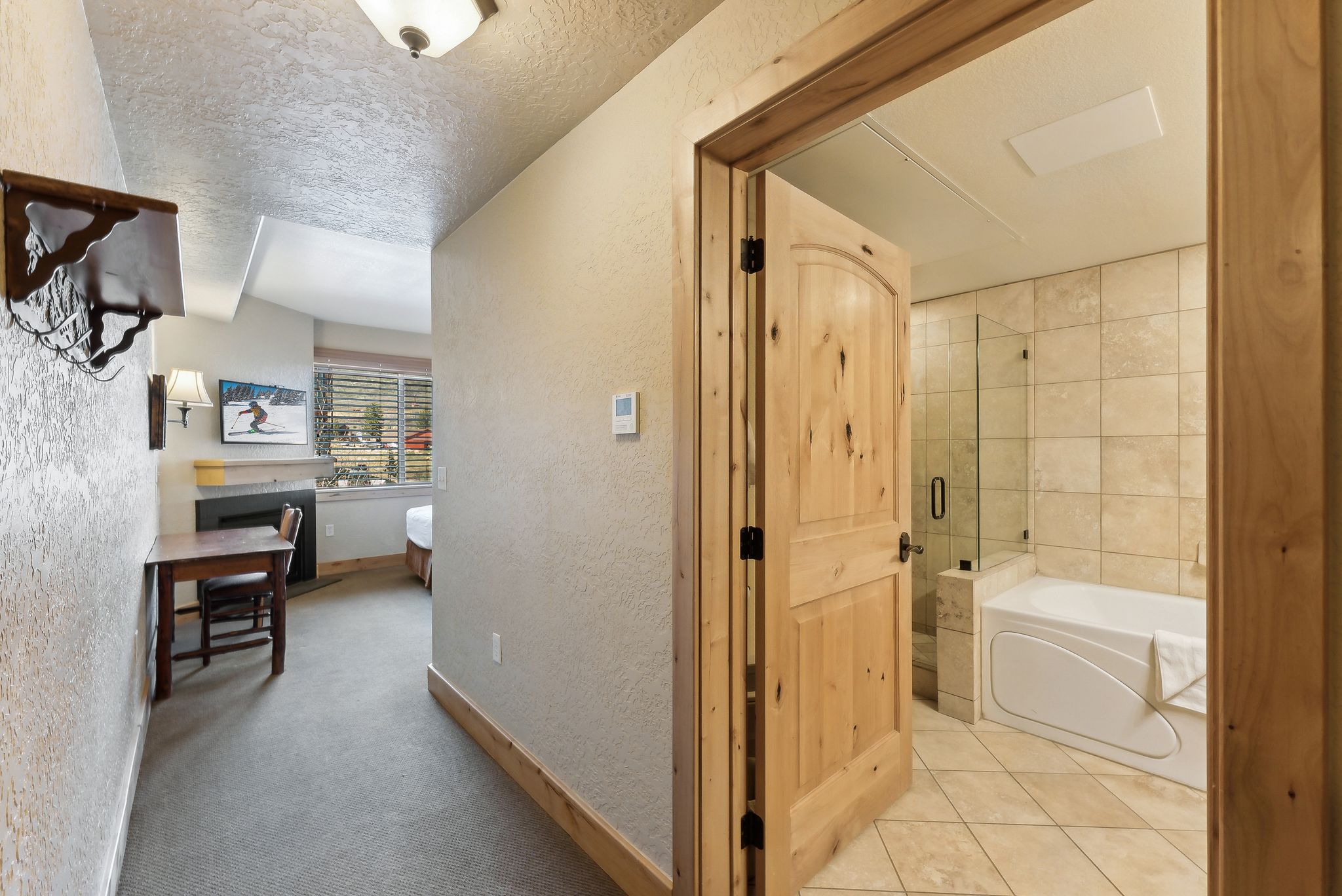 Bathroom featuring an alcove soaking tub, glass-enclosed shower, and tile flooring