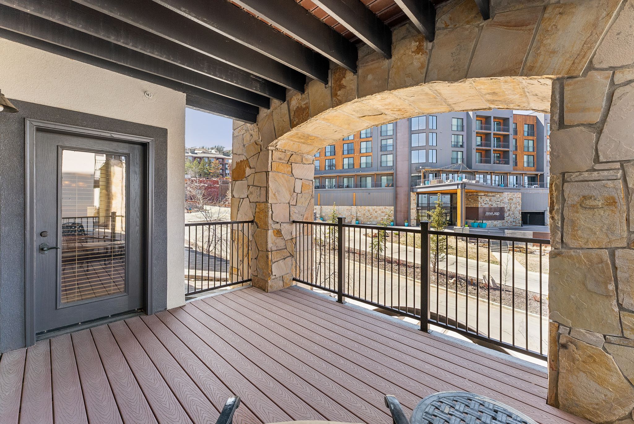 Outdoor balcony featuring durable composite decking and a stone archway
