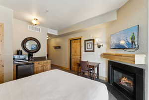 Bedroom featuring baseboards, a glass covered fireplace, and visible vents