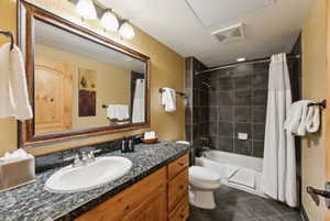 Full bathroom featuring toilet, vanity, shower / bath combo with shower curtain, and visible vents