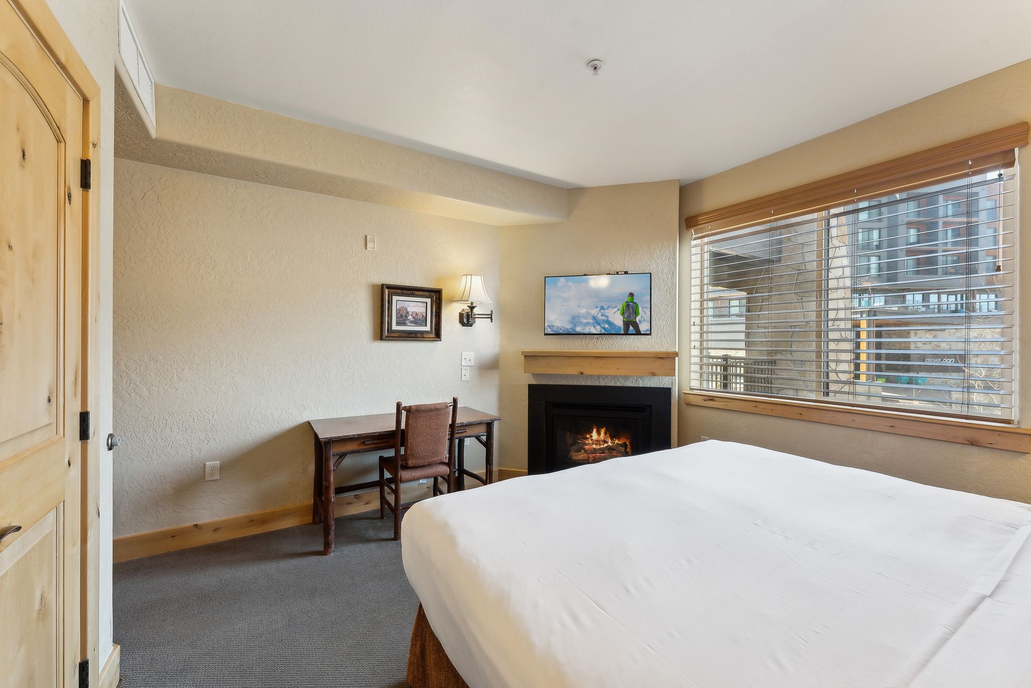 Built-in fireplace with wood-finish mantel and mounted television