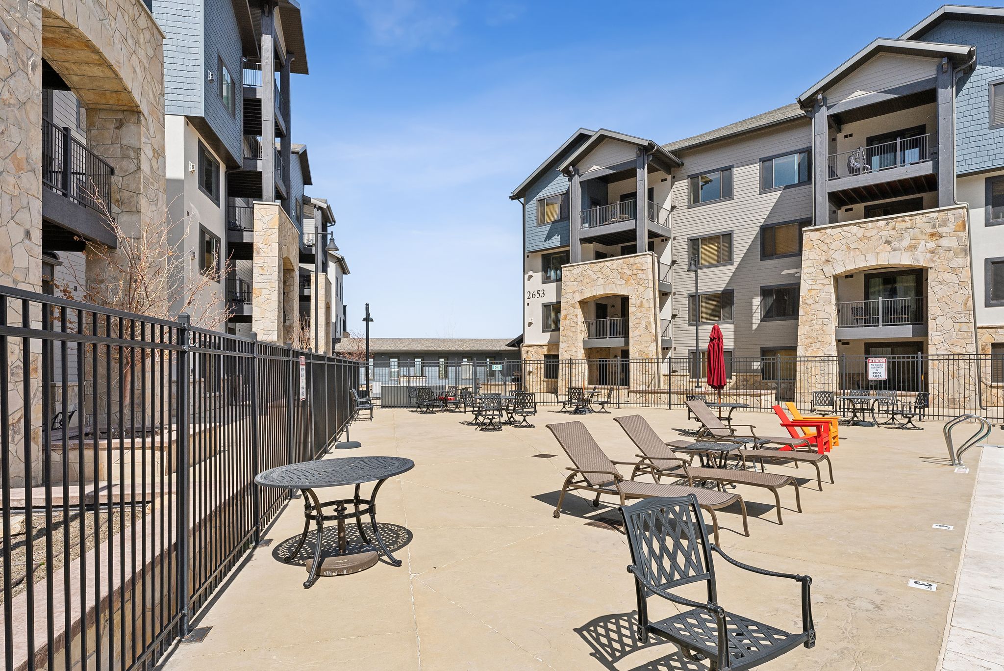 Concrete patio area surrounded by multi-level buildings featuring stone and siding exteriors