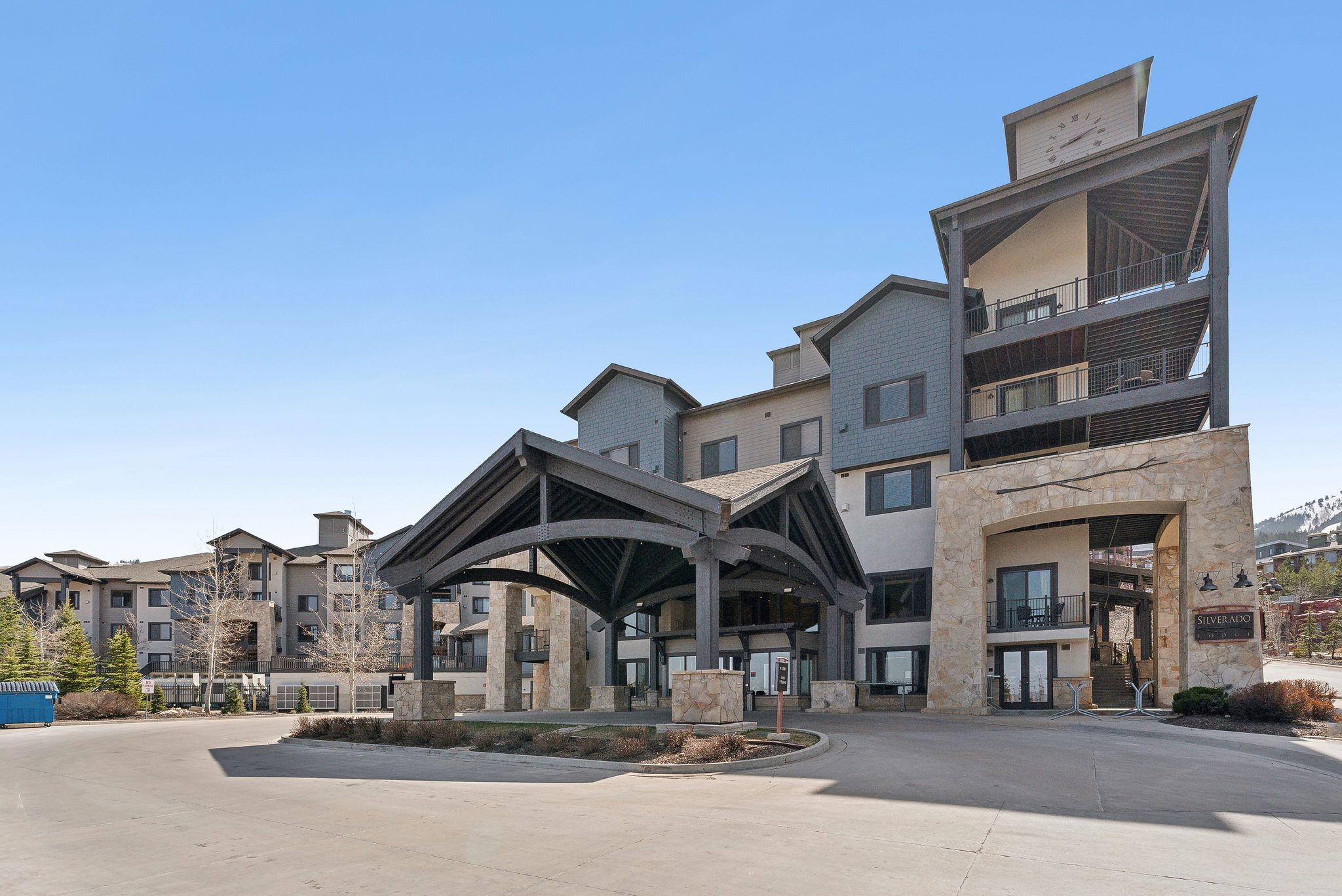 Multi-story residential building featuring a stone and siding exterior