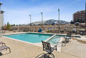 Pool featuring a mountain view, a patio area, and fence