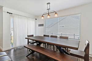 Dining room featuring dark wood-type flooring and baseboards