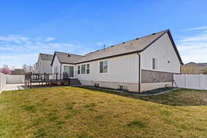 Back of house with a yard, a fenced backyard, a wooden deck, and a patio area