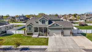 View of front of house with a residential view, driveway, fence private yard, and a front lawn