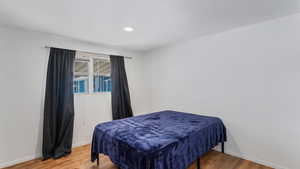 Bedroom with baseboards and wood finished floors