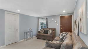 Living area with baseboards, carpet floors, and recessed lighting