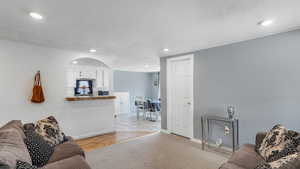 Living room with baseboards, a textured ceiling, and recessed lighting