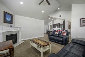 Living area with high vaulted ceiling, a ceiling fan, visible vents, recessed lighting, and baseboards