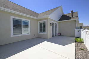 Back of property with roof with shingles, a patio, stucco siding, and fence