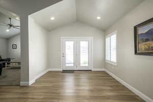 Doorway to outside with lofted ceiling, baseboards, recessed lighting, ceiling fan, and wood finished floors