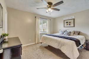 Bedroom featuring ceiling fan, carpet flooring, and baseboards