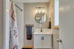 Full bath featuring a shower with shower curtain and vanity