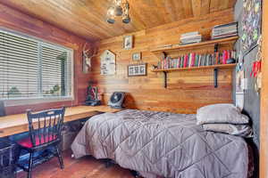 Bedroom with wood walls, wooden ceiling, and wood-type flooring