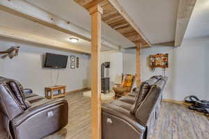 Living room featuring a wood stove, baseboards, and wood finished floors