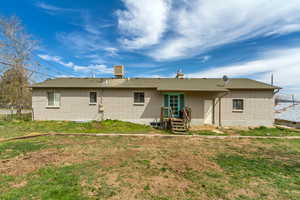 Back of property featuring roof with shingles, a yard, fence, and brick siding