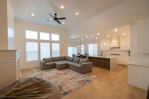 Living area with recessed lighting, a ceiling fan, and light wood-style floors